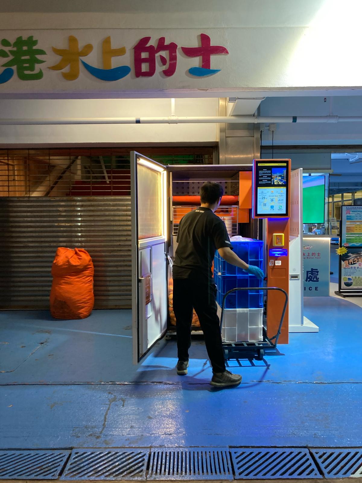 Photo by Vanessa Yeung: Staff refilling oranges at a juice vending machine